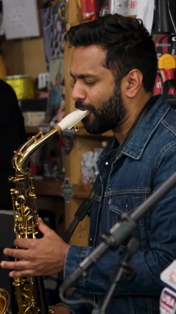 Tiny Desk AI music video frame: saxophone solo Tiny Desk AI music video frame featuring a saxophone solo in a small studio